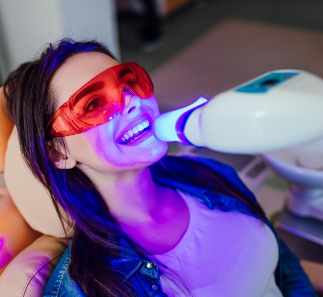 Patient receiving in dental office teeth whitening treatment