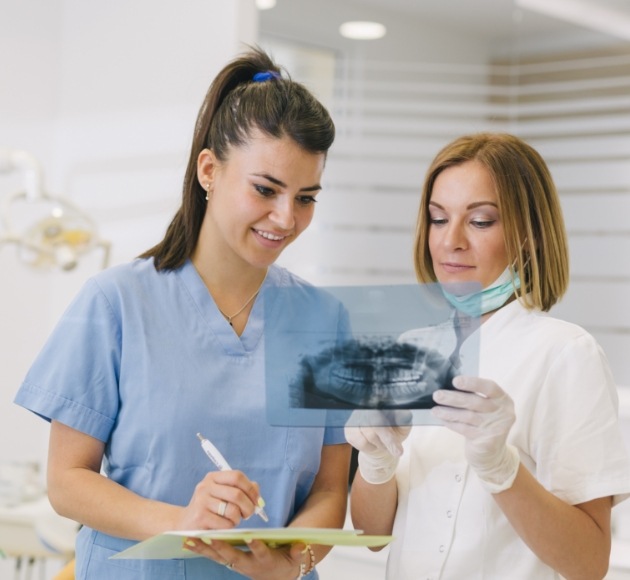 Dentist and team member reviewing x-rays