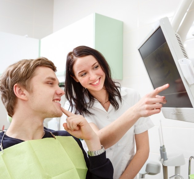 Dentist and patient looking at digital x-rays on computer screen