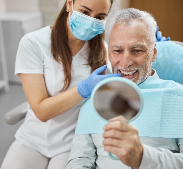 Dentist and patient reviewing the outstanding results of dentures supported by dental implants