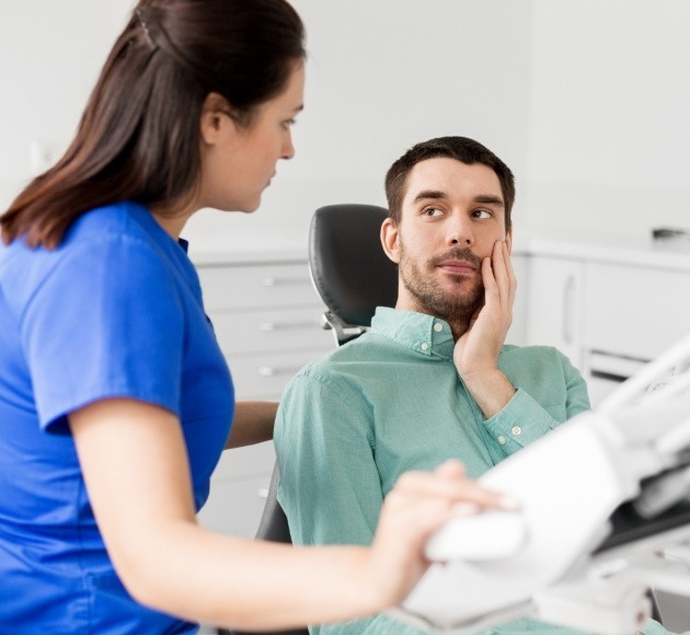 Man holding cheek before tooth extraction