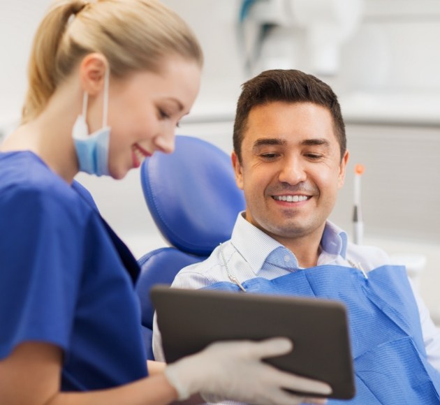Dentist and patient reviewing the four step dental implant process