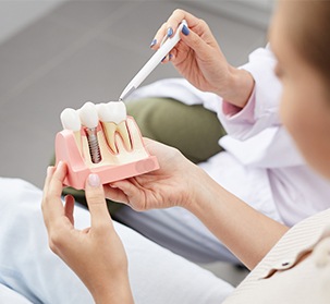 Dentist and patient looking at smile model during initial dental implant consultation