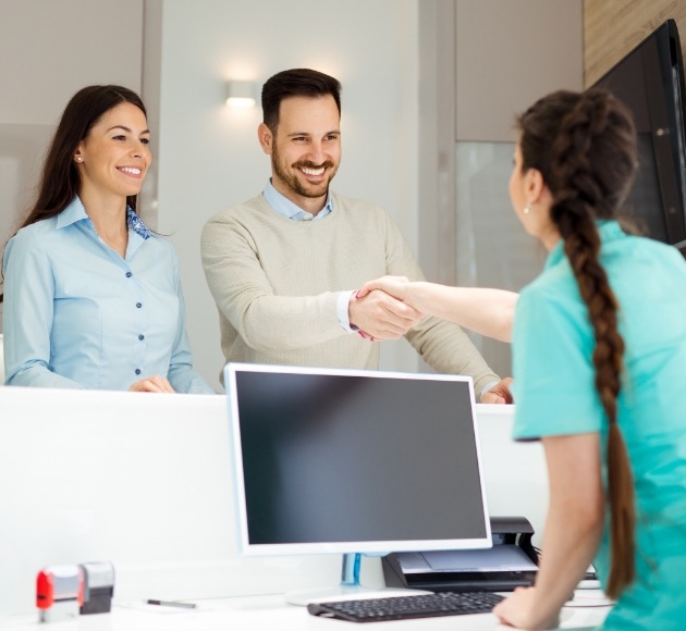 Dental patients discussing how dental insurance works with dental team member