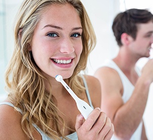 couple brushing teeth together in bathroom