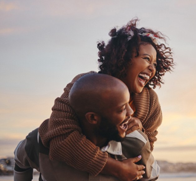 couple laughing together at the beach 