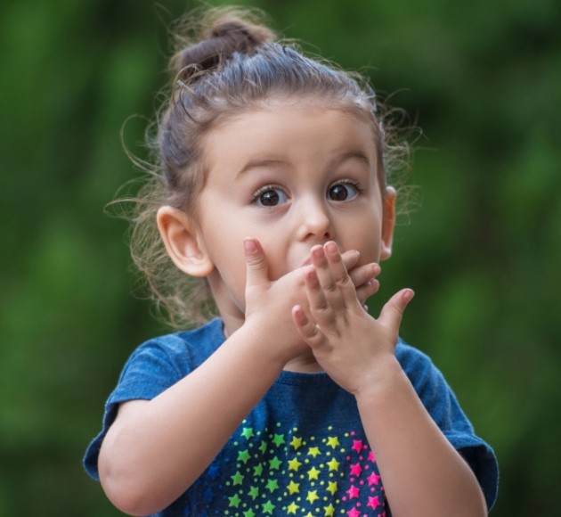 Child covering mouth after damage caused by thumb sucking