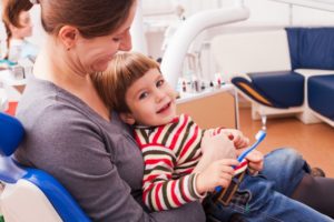 woman sitting with child dentist chair