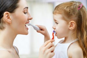 Mom teaches daughter how to brush teeth during quarantine