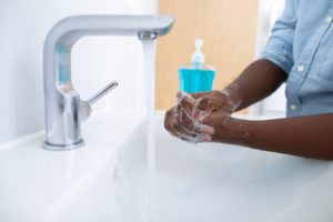 Someone washing their hands with tips from a dentist in Natick 