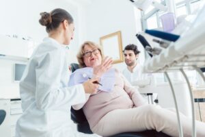 older patient talking to the dentist about dental implants